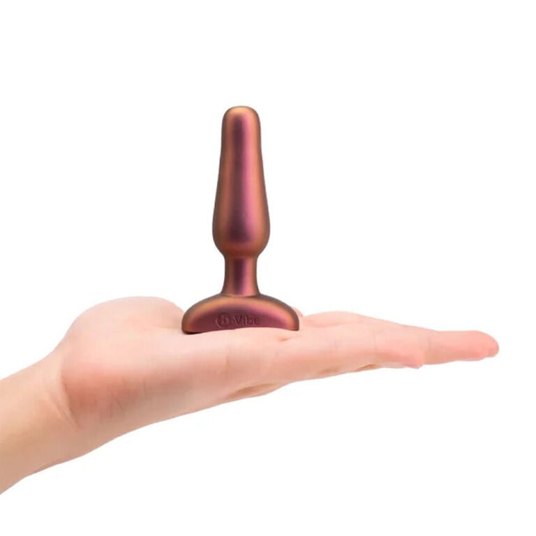 A rose gold Vibe vibrator held in a person's hand, designed for intimate pleasure, featuring ergonomic shape and quiet operation, ideal for personal use and sexual wellness.