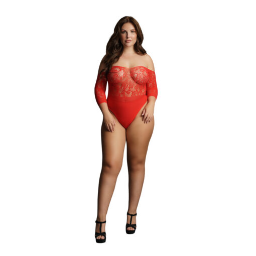 A woman is posing in a red lace bodysuit.