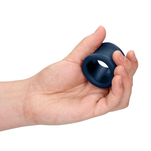 A person's hand holding a blue rubber ring.