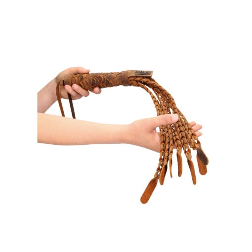 A person's hand is holding a wooden sword.