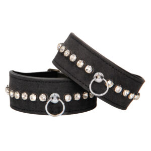 A pair of black leather chokers with rhinestones.