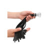 A person holding a black leather tassel.