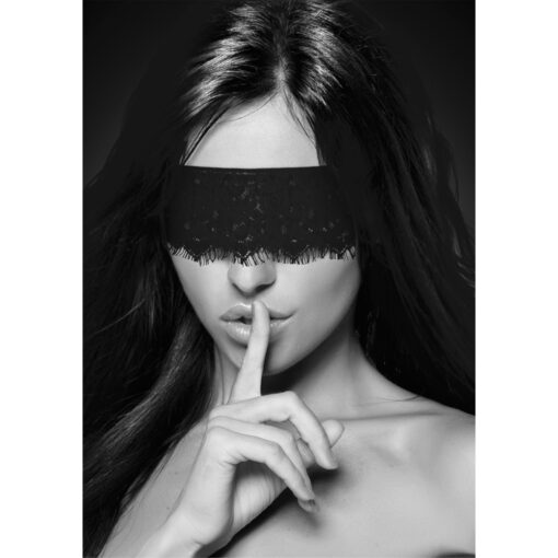 A woman with long hair covering her mouth with a black blindfold.