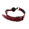 A red leather collar with a black ball on it.