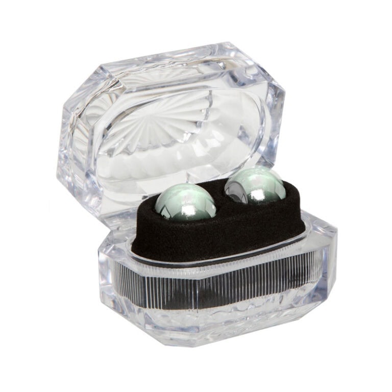 Elegant transparent crystal case with metallic balls, designed for storing and displaying adult pleasure accessories discreetly and stylishly.