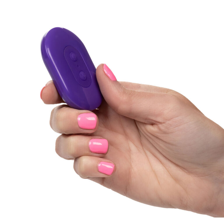 Hand holding a purple silicone remote control ribbed bullet vibrator