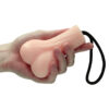 A hand holding a pink toy with a rope attached to it.