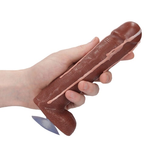 A hand holding a brown dildo toy.