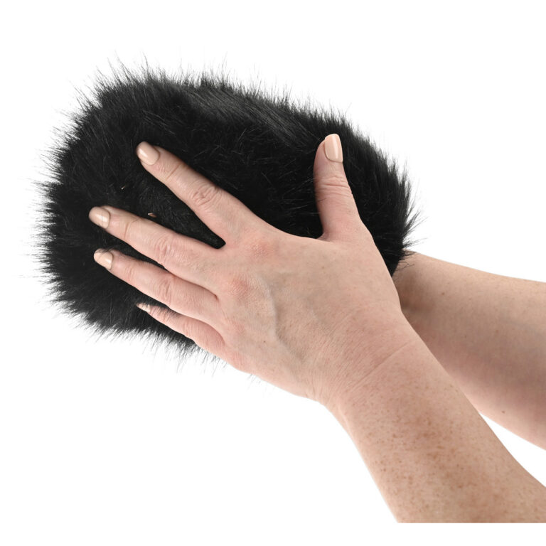 A person holding a soft, black faux fur hand warmer, showcasing a luxurious and cozy accessory for comfort and style.