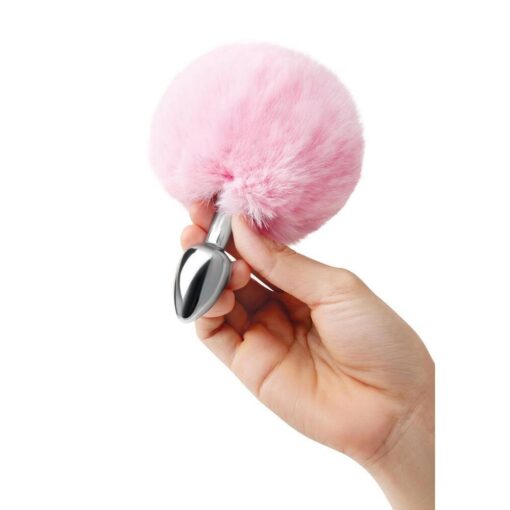 A hand holding a pink furry ball.
