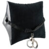 A black pillow with handcuffs attached to it.