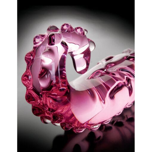 A pink glass octopus on a black background.