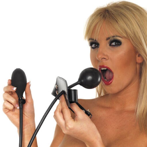 A blond woman is holding a black sex toy.