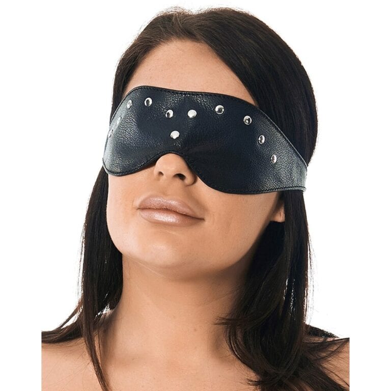 Woman wearing a black leather blindfold with metal studs, enhancing sensory play and intimacy, ideal for adult pleasure and BDSM experiences.