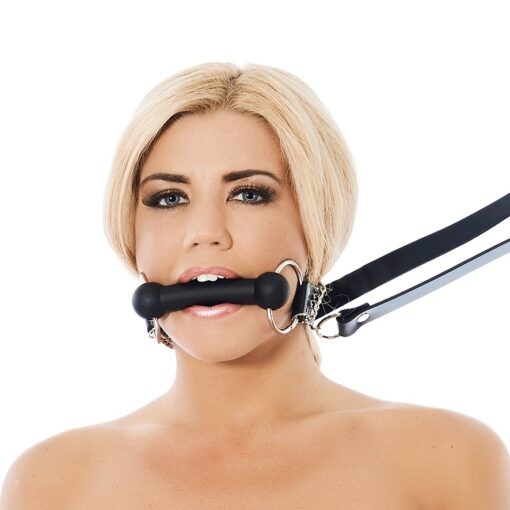 A woman is holding a black leather gag.